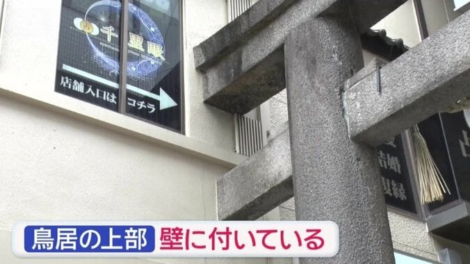 鳥居の上の部分がビルの壁に