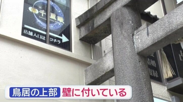 鳥居の上の部分がビルの壁に