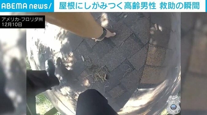 屋根の上に救助に向かう警察