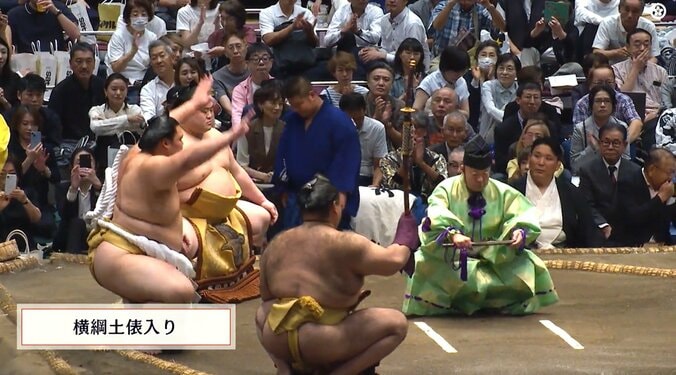 審判を務める元関脇・朝赤龍の高砂親方の背後から