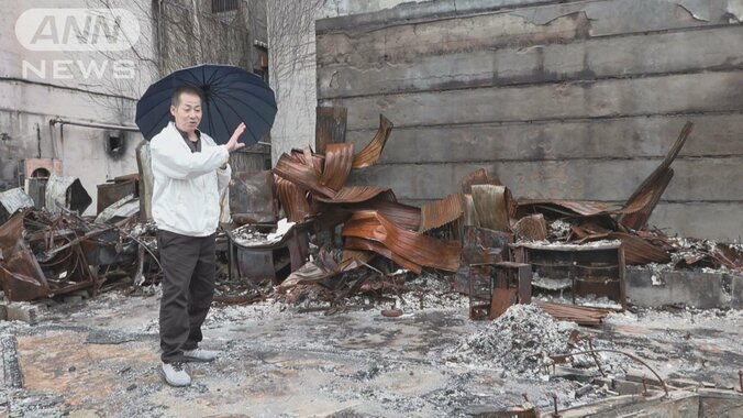 店の焼け跡で震災当時を振り返る紙浩之さん=2024年2月