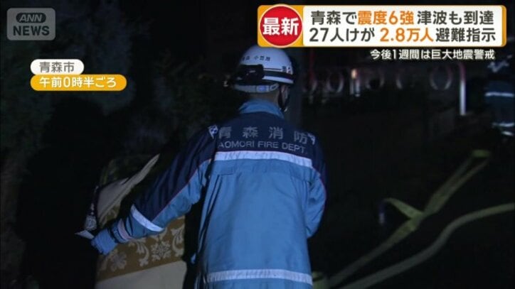 消防隊員に体を支えられながら避難する人