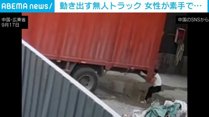 トラックにしがみつく女性