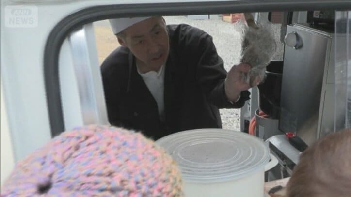 お客さんに魚を見せる紙さん