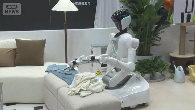 服をたたむ人型ロボット　パフォーマンスから実用へ 北京で大会、300社が出展 1枚目