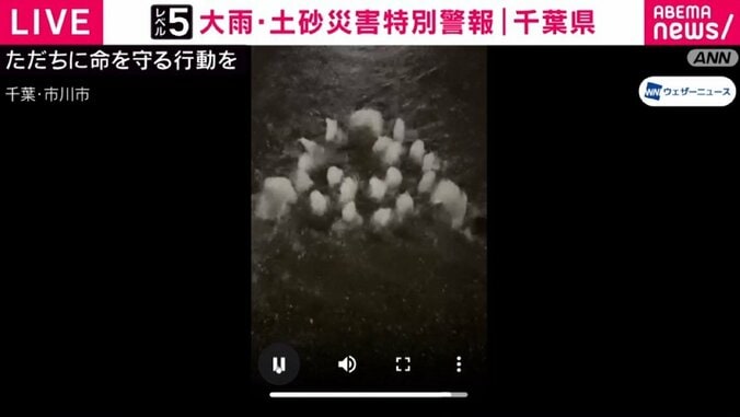 マンホールの蓋の穴から吹き出す雨水