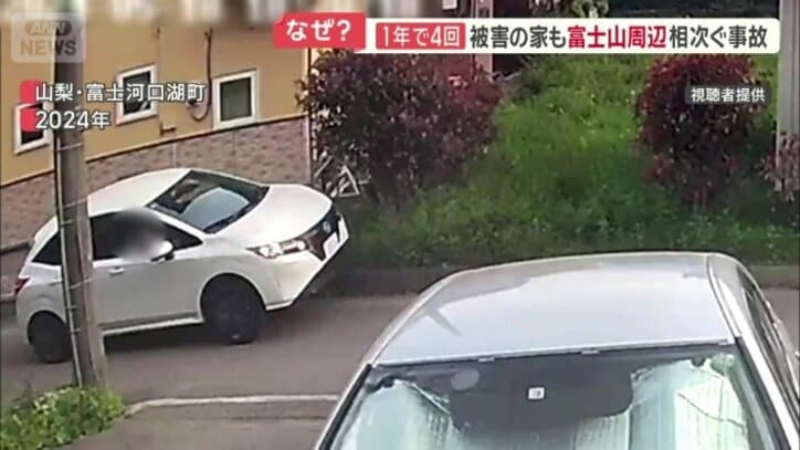 塀に乗り上げる白い車
