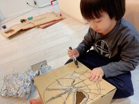 アレクサンダー『ダンボールや　ペットボトル　アルミホイルで遊んでます』