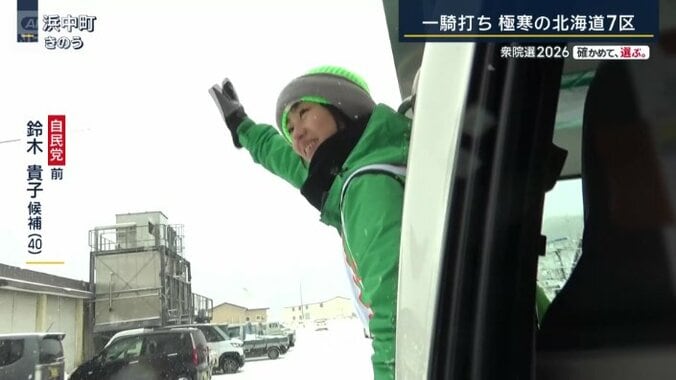 車から身を乗り出す鈴木候補