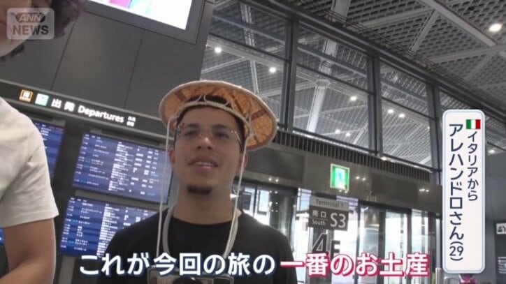 すげ笠をかぶる外国人観光客