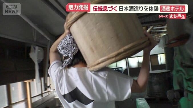 蒸したコメをたるで運ぶ