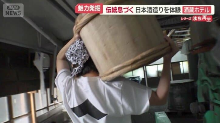 蒸したコメをたるで運ぶ