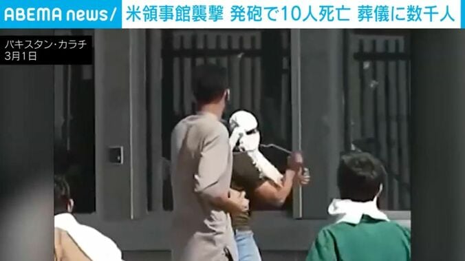 ガラスを割ろうとする抗議者