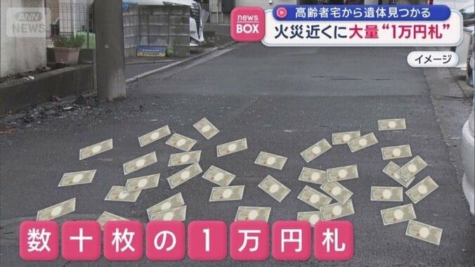住宅の前に数十枚の1万円札