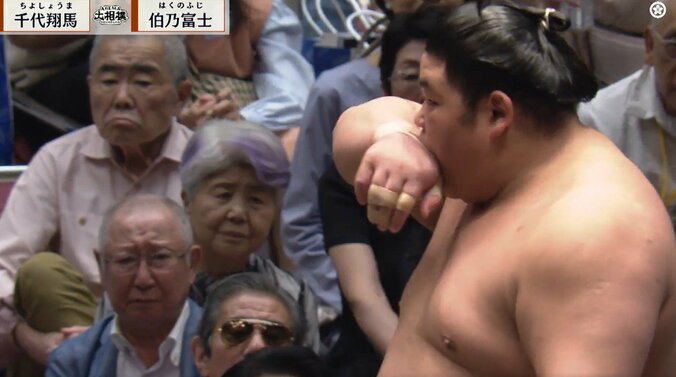 口を押え苦い顔の伯乃富士