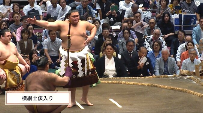 審判を務める元関脇・朝赤龍の高砂親方の背後から