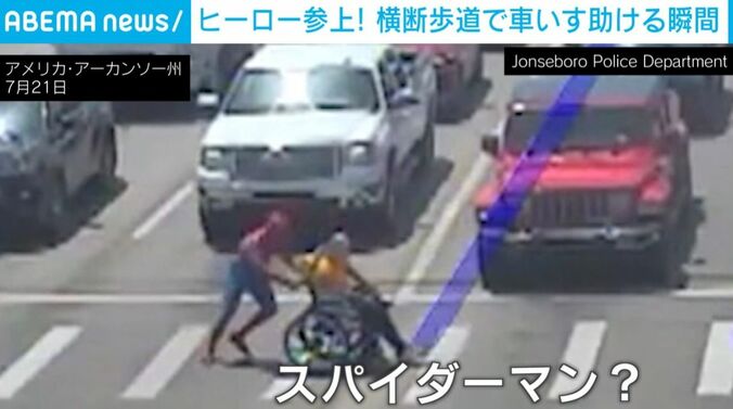 “スーパーヒーロー”と車いすの男性