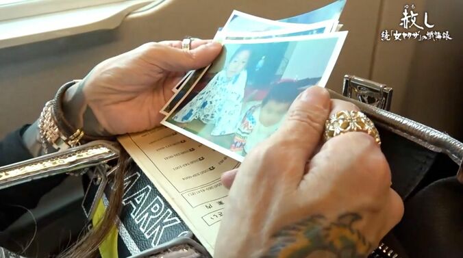 息子たちの写真を見つめる西村