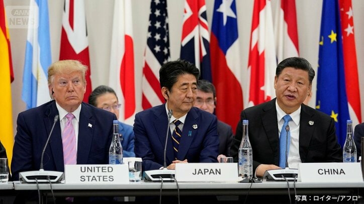 2019年6月28日、大阪で開催されたG20首脳会議での会合中、安倍晋三首相を挟んで並ぶドナルド・トランプ米大統領と習近平中国国家主席。