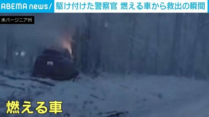 雪道の高速道路の側で炎上する車
