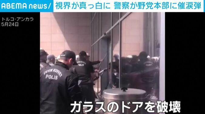 ガラスのドアを破壊する警察