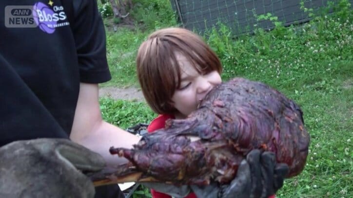 シカの脚の肉を丸かじり