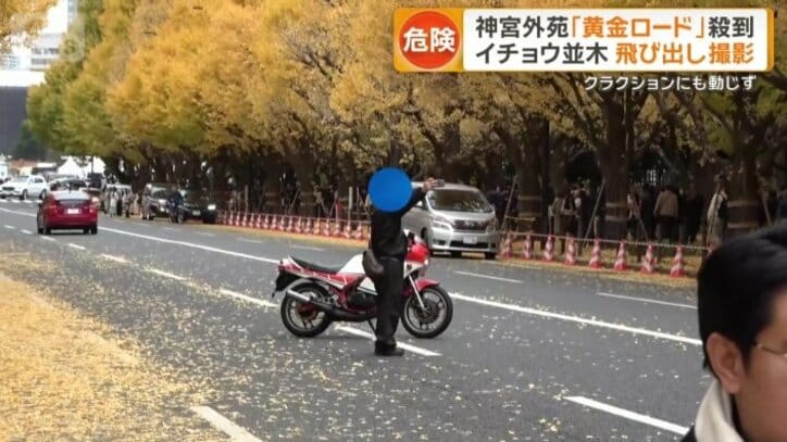 バイクと一緒に車道の真ん中で撮影している男性