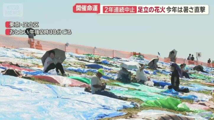 日傘で耐えながら花火を待つ観客