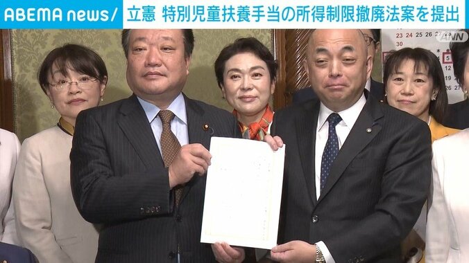 法案を持っている岡本議員ら