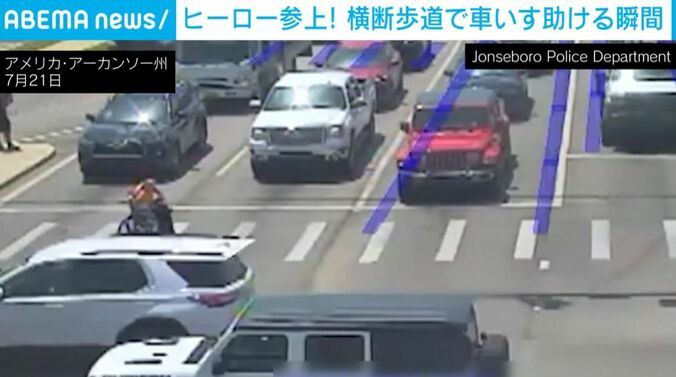“スーパーヒーロー”と車いすの男性