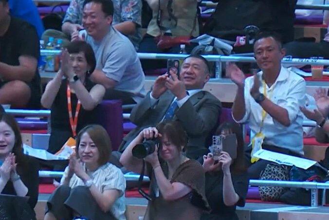 グレーのスーツ姿のパラダイス山元さん（写真中央）