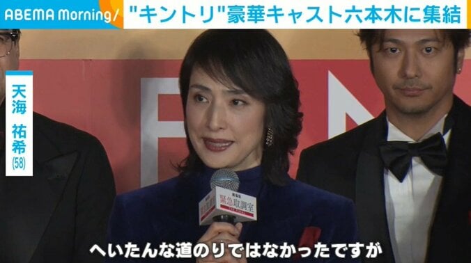 青いパンツスーツ姿の天海祐希