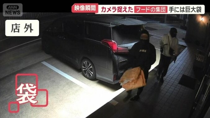 手にはオレンジ色の袋のようなものが