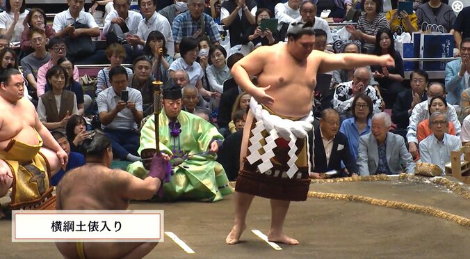 審判を務める元関脇・朝赤龍の高砂親方の背後から
