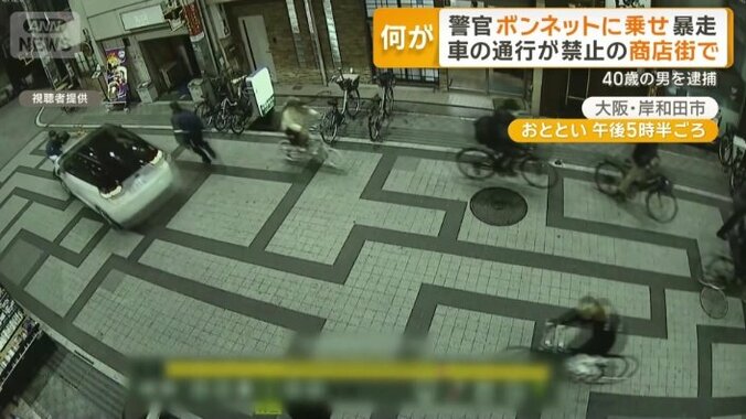 制止する警察官をボンネットに乗せる