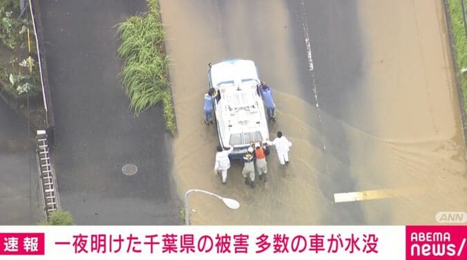 手で車を押す人ら