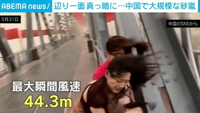 突風に煽られる人ら