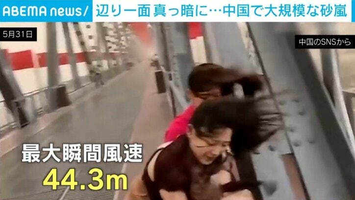 突風に煽られる人ら