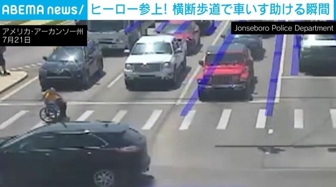 “スーパーヒーロー”と車いすの男性