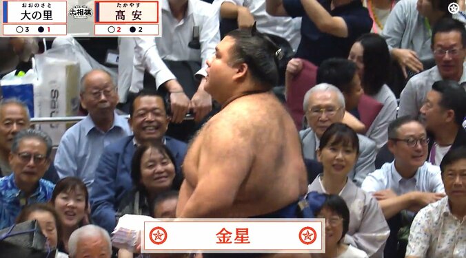 飛んできた座布団を手にする女性