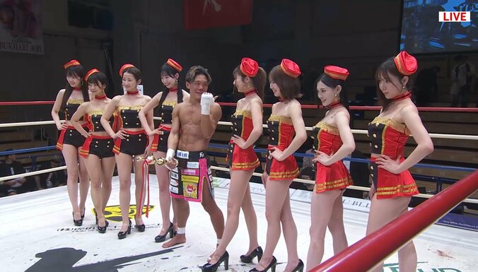 トロフィーを股間に当てラウンドガールと記念撮影