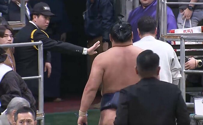 豊昇龍の近くの客を制する警備員