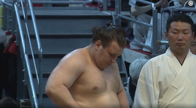 驚いた様子で安青錦を見つめる呼出