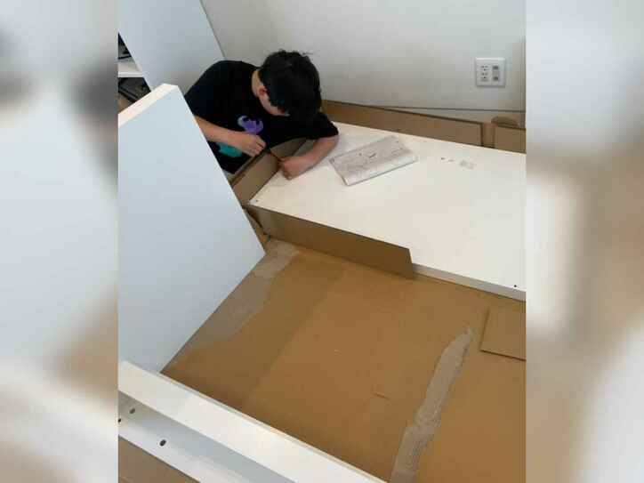【写真】デスクを組み立てる息子さん