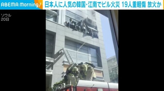 ビルから身を乗り出し助けを求める人ら