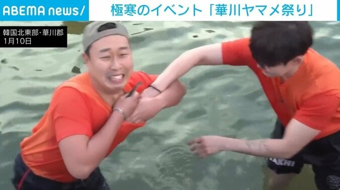 ヤマメをTシャツに入れる参加者