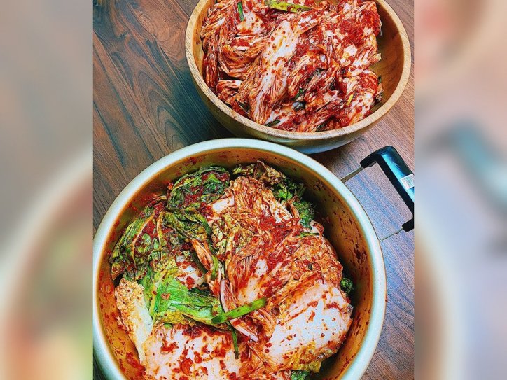 【写真】大きな鍋、容器にキムチの材料である白菜、ニラ、唐辛子などが詰められている。