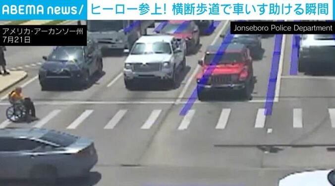 “スーパーヒーロー”と車いすの男性