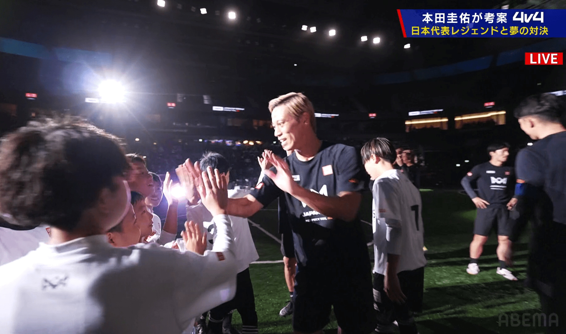 試合後に子供達とハイタッチをする本田圭佑